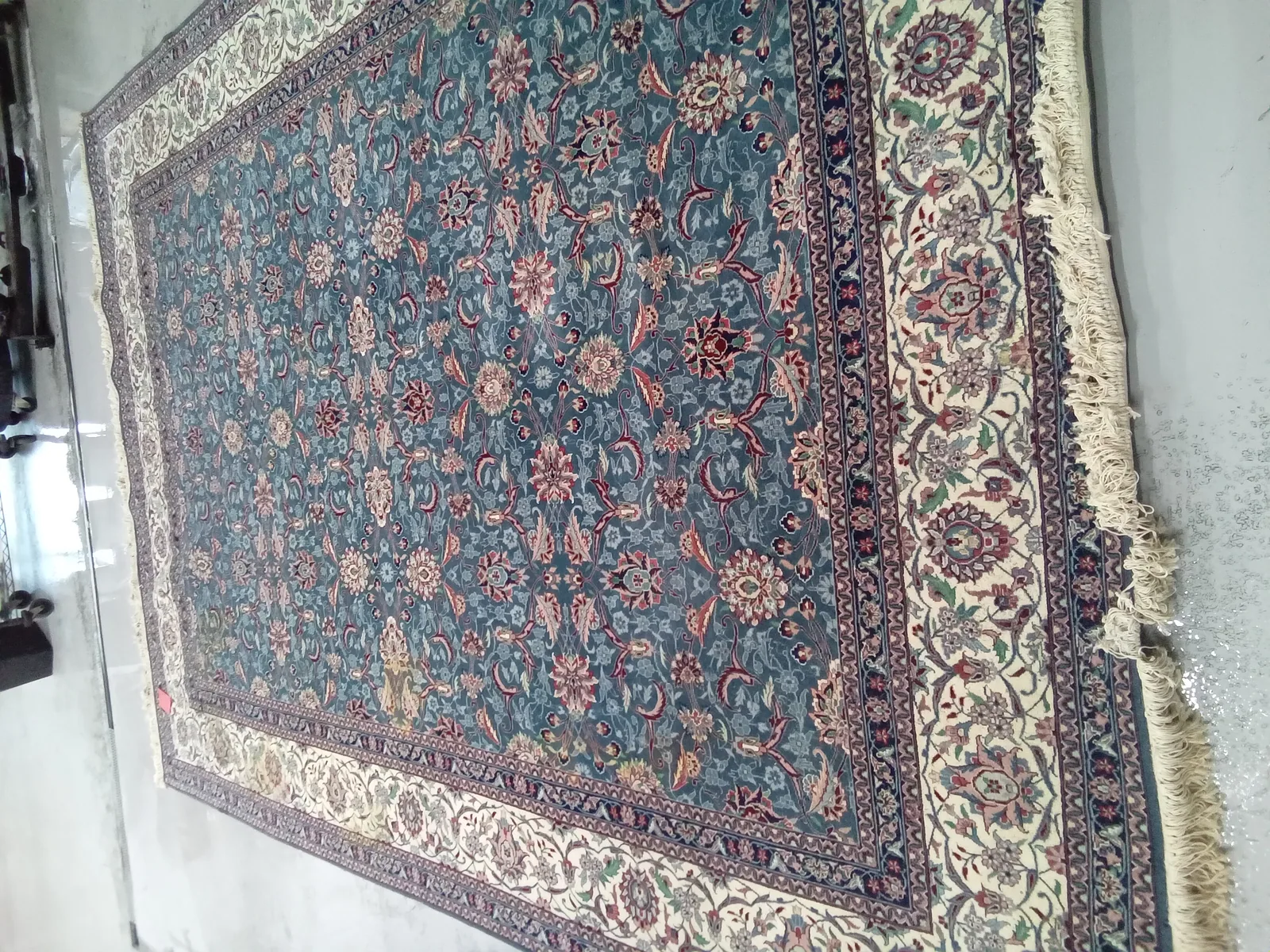 The border and field of a blue and cream Persian rug, picked up in Aventura