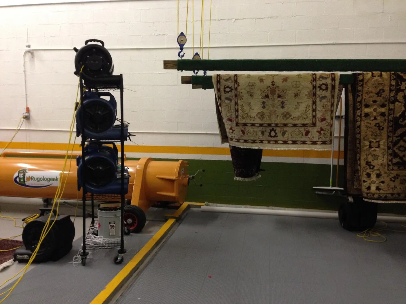 Washed rugs hung on beams in the plant drying room